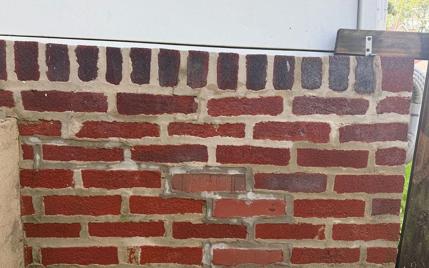 The same Lansdowne, PA brick retaining wall after pressure washing, the brick a deep red and the mortar joints clean