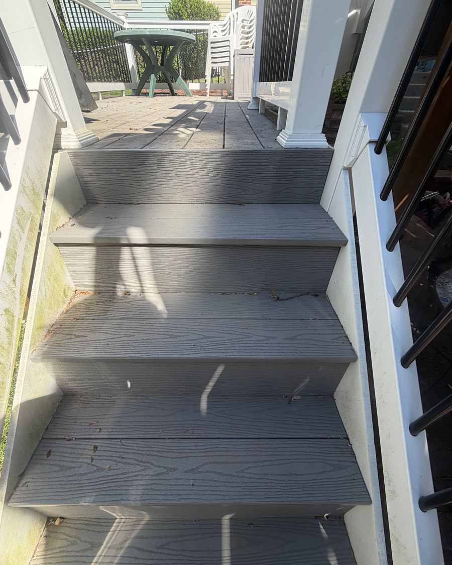 Composite deck stairs in Havertown, PA before washing, green growth along the white stringer