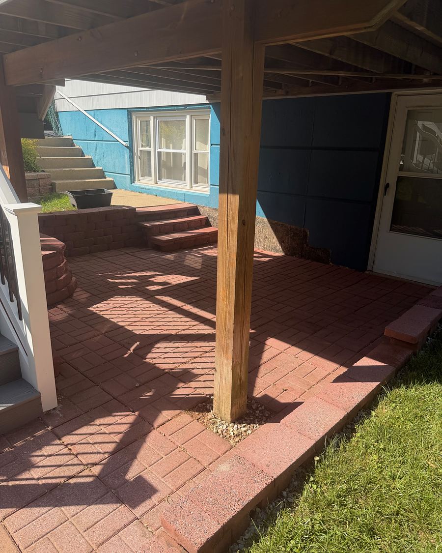 The same paver patio under the deck after washing, the brick a clean even red