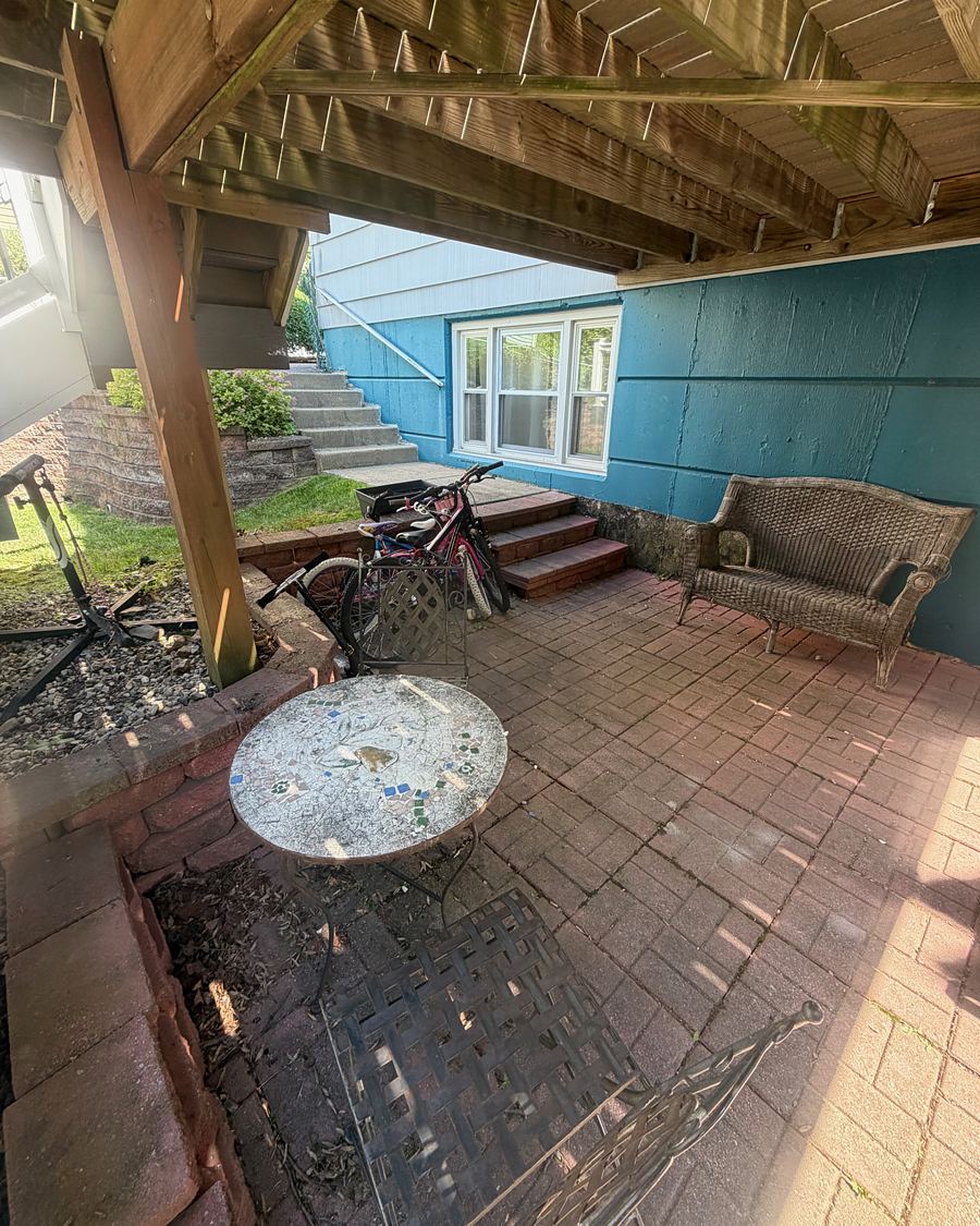 Brick paver patio under a deck in Havertown, PA before washing, dark and covered in grime