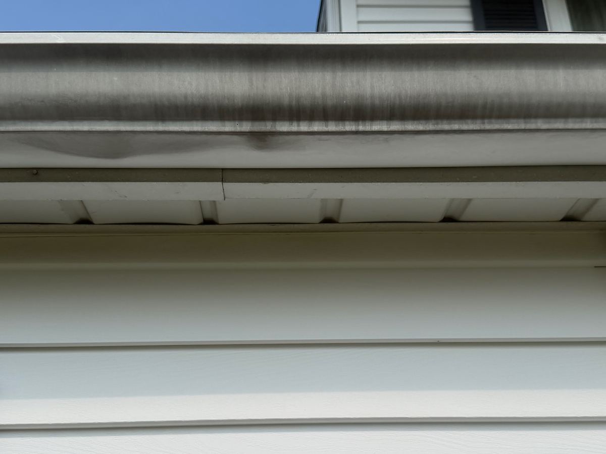 White gutter on a Hatboro, PA home before gutter brightening, the whole face covered in black streaks